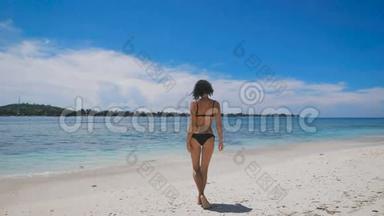 在<strong>炎热</strong>的<strong>夏天</strong>，穿着黑色比基尼在巴厘岛海滩上晒太阳。 很适合年轻女孩